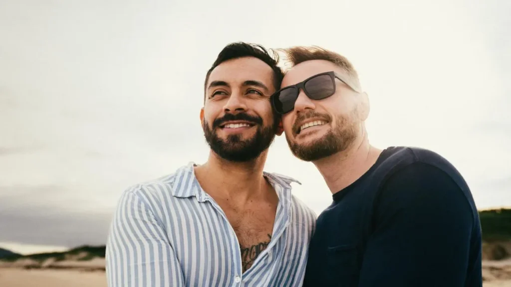 Zwei Männer lächeln am Strand – Symbolbild für Hypnose bei Beziehungsproblemen und mehr Nähe, Vertrauen und bessere Kommunikation